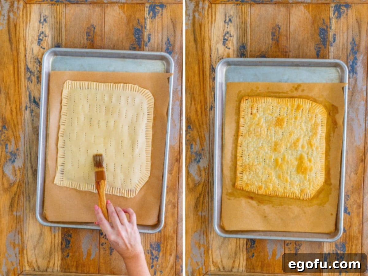 A hand brushing water over the edges of the bottom pie crust with filling.