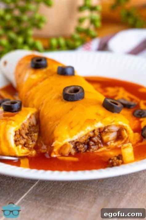 A beautifully broken open Taco Bell copycat Enchirito, revealing its savory layers and toppings.