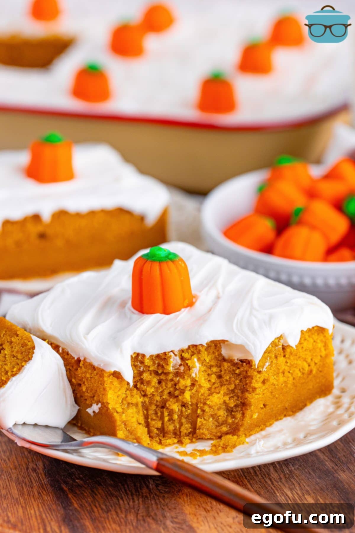 Decadent Pumpkin Pie Cake 2 A perfectly sliced piece of Pumpkin Pie Cake, revealing its moist texture and rich layers, with a bite missing to show its inviting appeal.