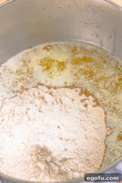 Decadent Pumpkin Pie Cake 11 Wet and dry ingredients for the cake combining in a mixing bowl, showcasing the consistency of the batter.