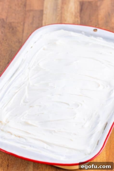 Decadent Pumpkin Pie Cake 13 A frosted Pumpkin Pie Cake still in its baking pan, ready for slicing.