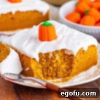 Decadent Pumpkin Pie Cake 9 Close up looking at a slice of Pumpkin Pie Cake with a bite missing, showcasing its moist texture and delicious frosting.