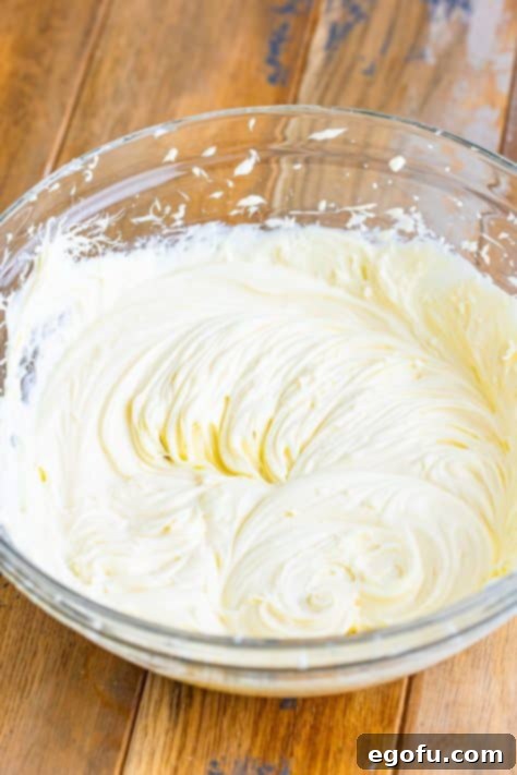 A bowl of cream cheese, powdered sugar, and vanilla extract.