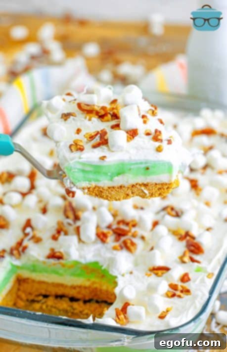 A slice of Pistachio Lush being held above the rest of the dessert pan.