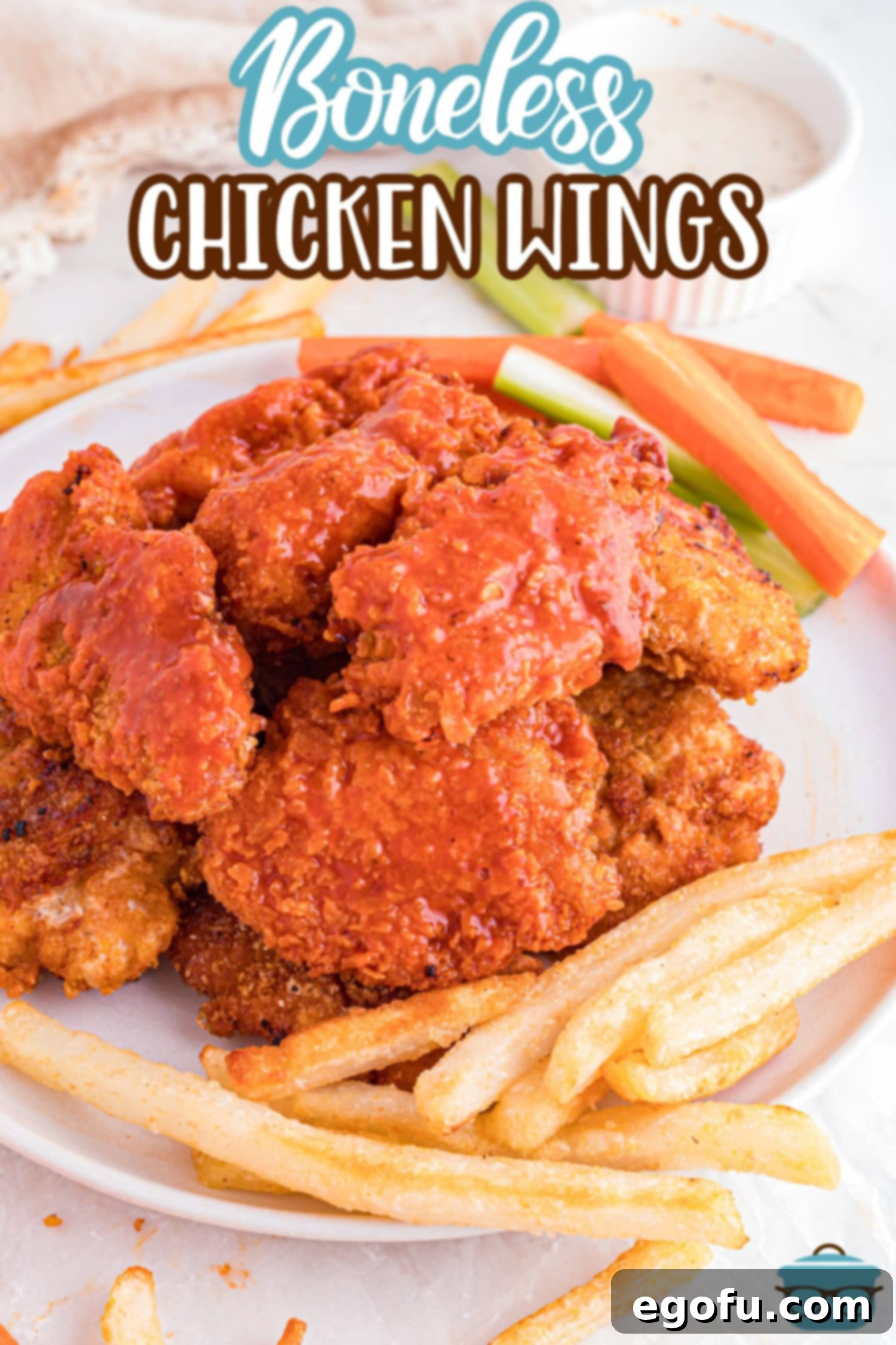 A plate of fries with Boneless Chicken Wings.