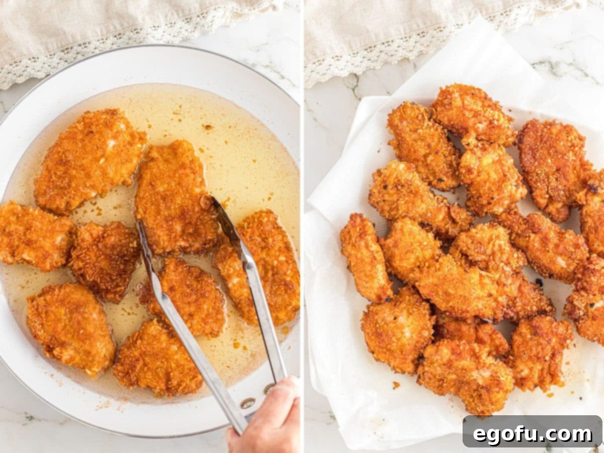 Tongs flipping boneless wings in oil and setting on some paper towels to drip oil.