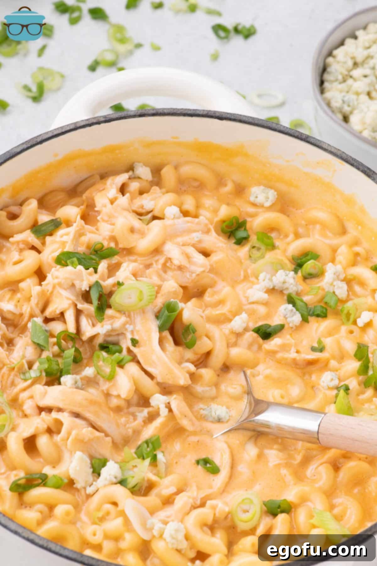 A serving utensil in a big pot of Buffalo Chicken Mac and Cheese.