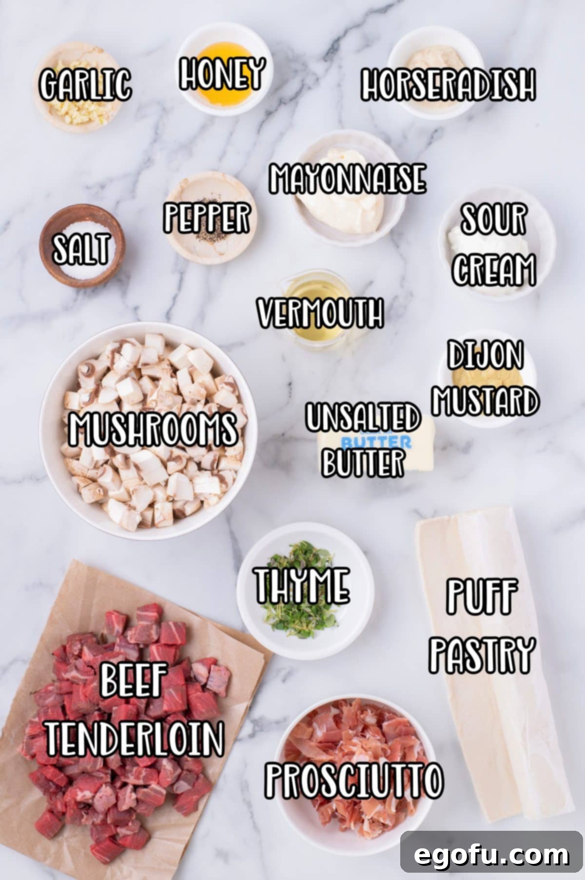 Garlic, honey, horseradish, salt, pepper, mayo, sour cream, mushrooms, vermouth, Dijon mustard, butter, thyme, beef tenderloin, prosciutto, and puff pastry.