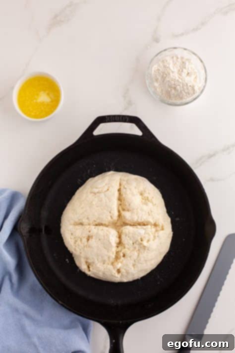 Celtic Loaf 12 Scored loaf of raw Brown Bread in a cast iron skillet.