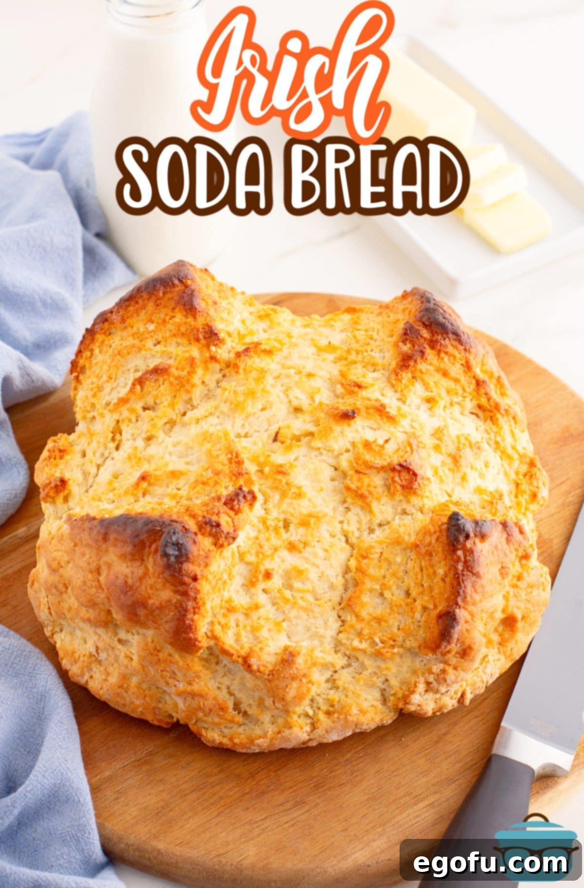 Celtic Loaf 3 A freshly baked, rustic loaf of homemade Irish Soda Bread with a signature cross scored on top, glistening with melted butter and presented beautifully on a wire cooling rack.