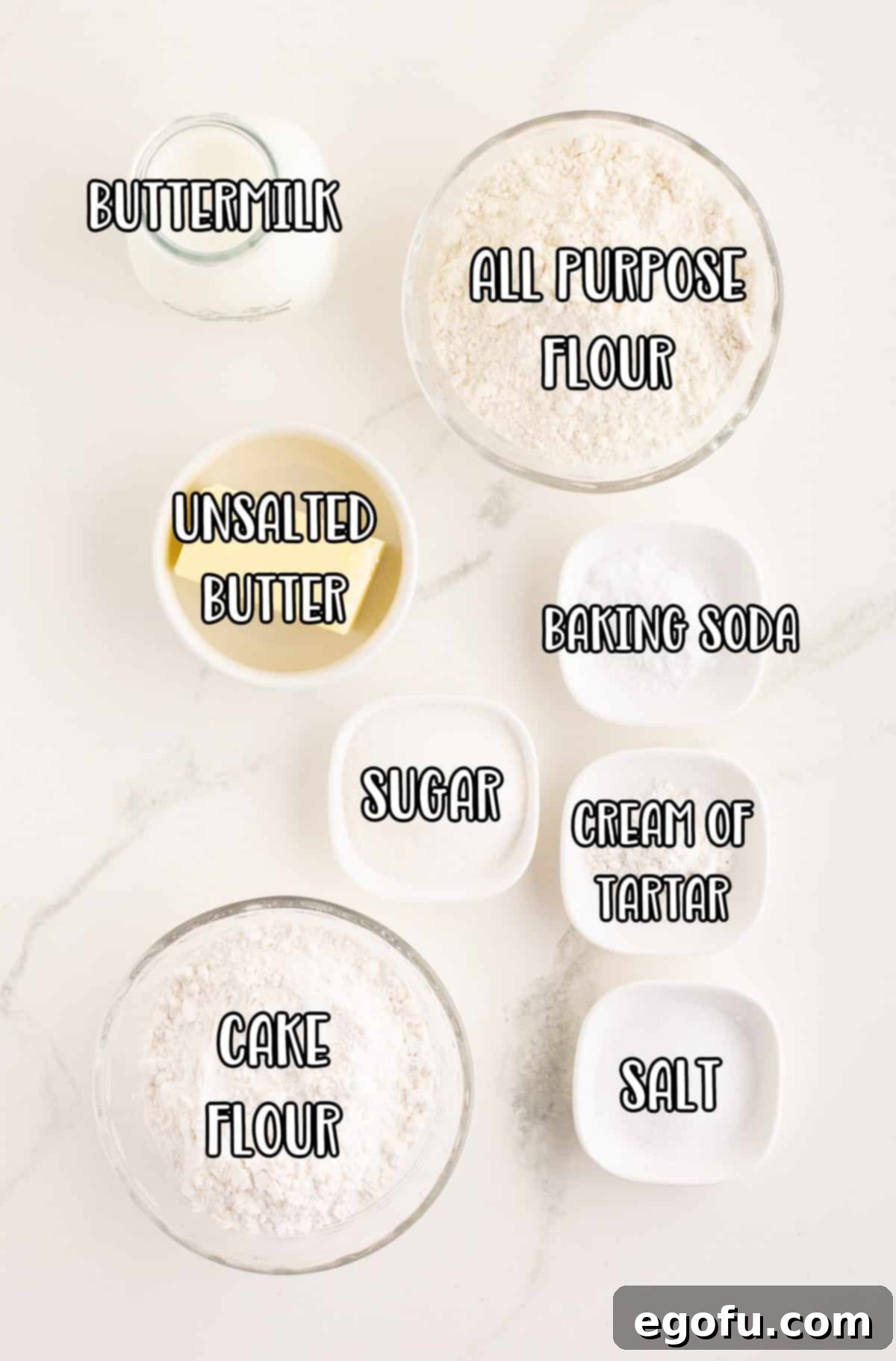 Celtic Loaf 4 A flat lay photograph showcasing all the key ingredients for Irish Soda Bread: all-purpose flour, cake flour, granulated sugar, baking soda, cream of tartar, salt, softened unsalted butter, and a jug of buttermilk, neatly arranged for baking.