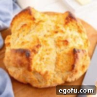 Celtic Loaf 9 Closely looking down on a fresh, round loaf of Irish Soda Bread, with its traditional scored cross, showcasing a perfect golden-brown crust.