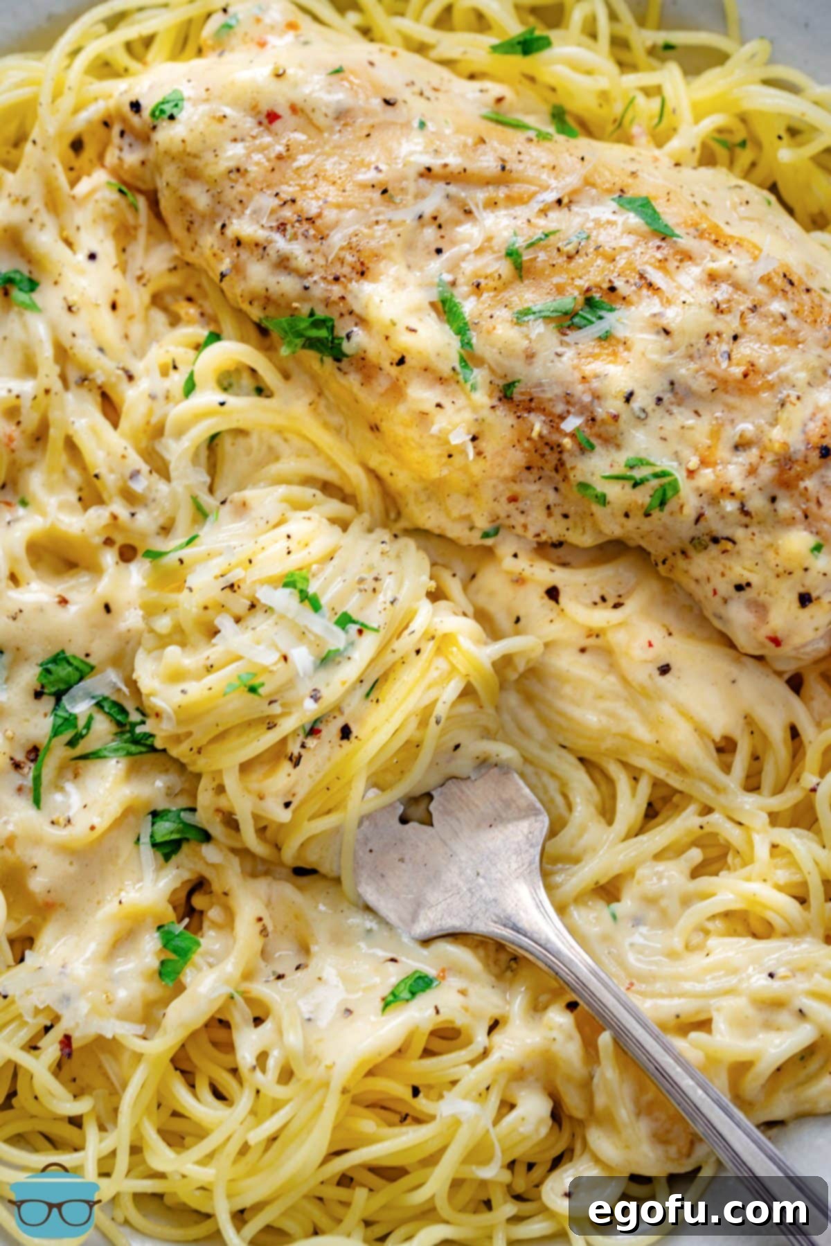 Effortless Slow Cooker Angel Chicken 2 Looking down on a large serving of Crock Pot Angel Chicken with a fork in the pasta.