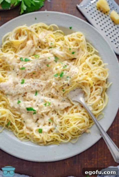 Effortless Slow Cooker Angel Chicken 16 A fork in a plate of Crock Pot Angel Chicken.