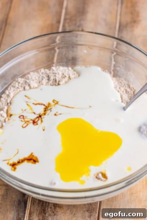 Ireland's Beloved Brown Loaf 10 A bowl with buttermilk, molasses, honey, and melted butter being added to dry ingredients.