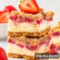 Luscious Strawberry Crumble Cheesecake Squares 5 A small stack of delightful Strawberry Crumble Cheesecake Bars, perfectly cut and ready to serve.