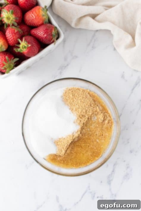 Luscious Strawberry Crumble Cheesecake Squares 6 A bowl of graham cracker crumbs, sugar, and melted butter, and the prepared crust in a baking dish, ready for baking.