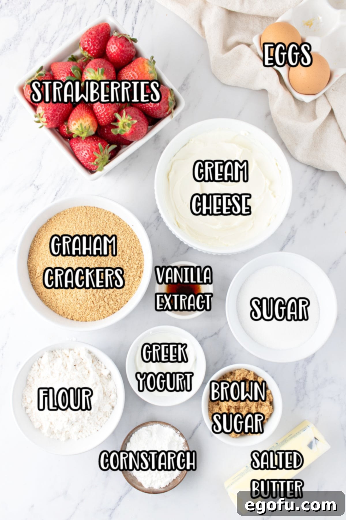 Luscious Strawberry Crumble Cheesecake Squares 4 A vibrant and appealing display of all the essential ingredients for Strawberry Crumble Cheesecake Bars, including fresh strawberries, cream cheese, sugars, eggs, butter, graham cracker crumbs, vanilla extract, flour, and cornstarch, beautifully arranged and ready for preparation.