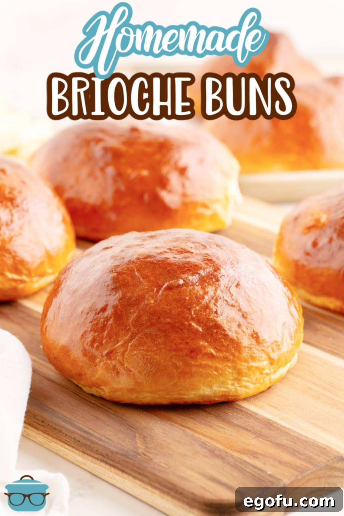 Golden Buttery Brioche Buns Fresh From Your Oven 3 A few golden brown Homemade Brioche Buns arranged on a serving platter.