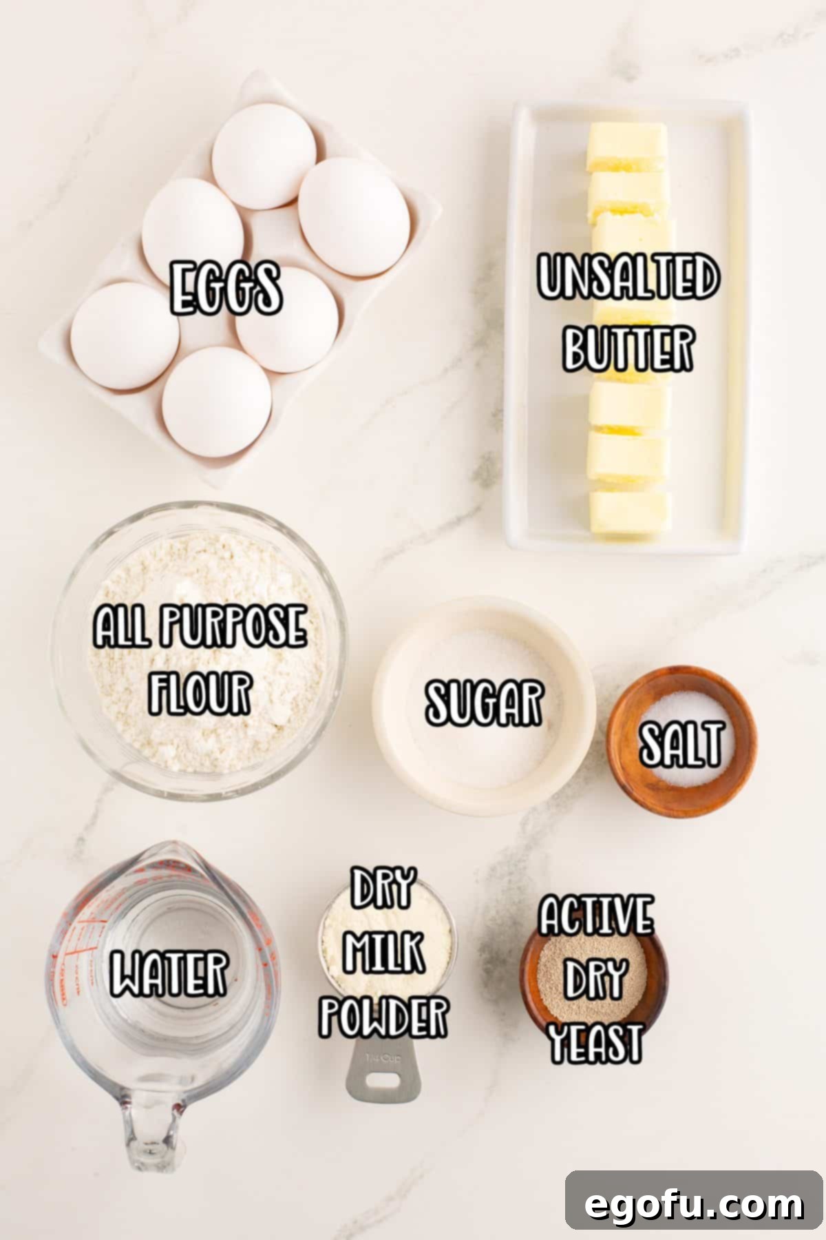 Golden Buttery Brioche Buns Fresh From Your Oven 4 A beautiful flat lay of unsalted butter, eggs, all purpose flour, sugar, salt, water, active dry yeast, and dry milk powder, all crucial ingredients for brioche buns.