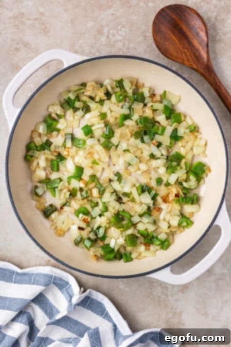 Peppers and onions cooking in a skillet.