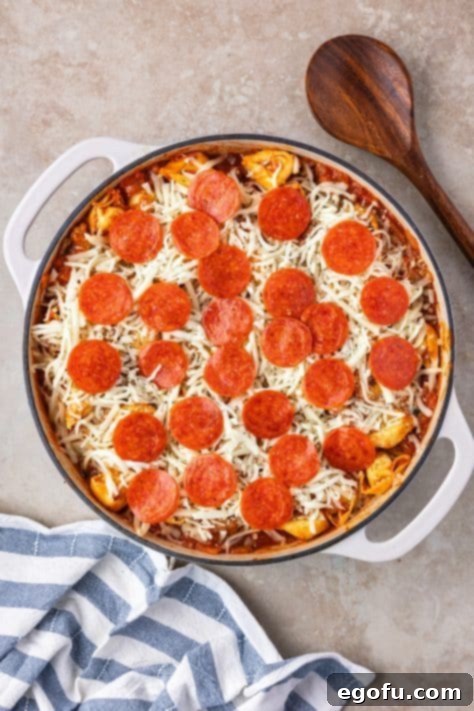 Tortellini, veggies, sauce, cheese, and pepperonis all in a skillet.