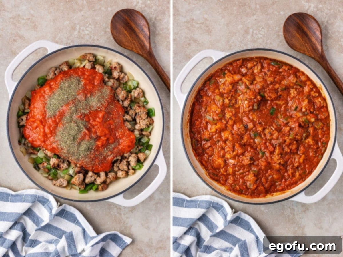 Peppers, onions, sausage, sauce, and seasoning simmering together in a skillet.