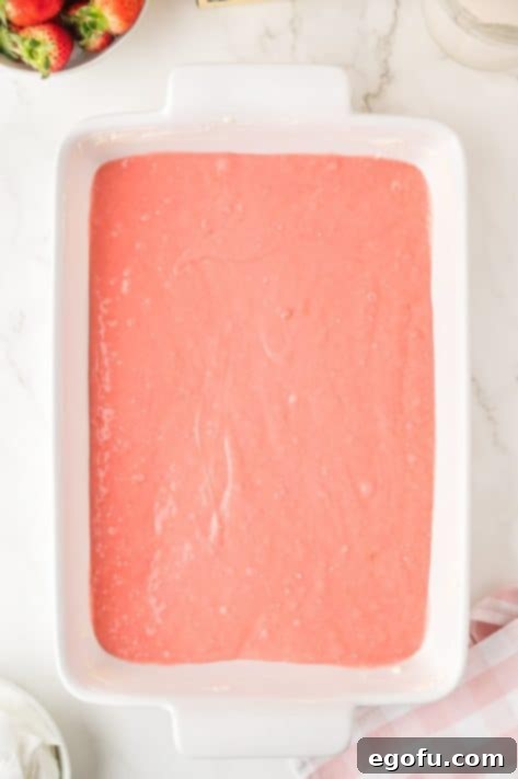 Velvety Strawberry Poke Cake Bliss 11 Strawberry Cake batter in a baking pan, ready for the oven.