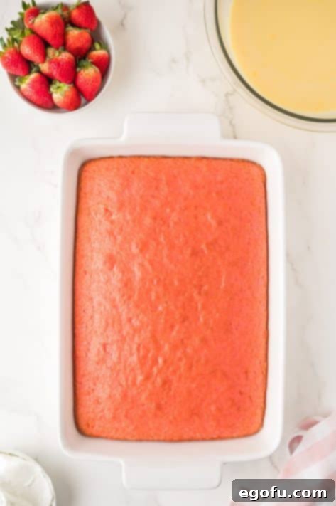 Velvety Strawberry Poke Cake Bliss 12 Baked strawberry cake in a dish, just out of the oven.