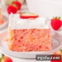 Velvety Strawberry Poke Cake Bliss 10 Closely looking at a slice of Strawberry Pudding Poke Cake on a dessert plate, highlighting its moist layers.