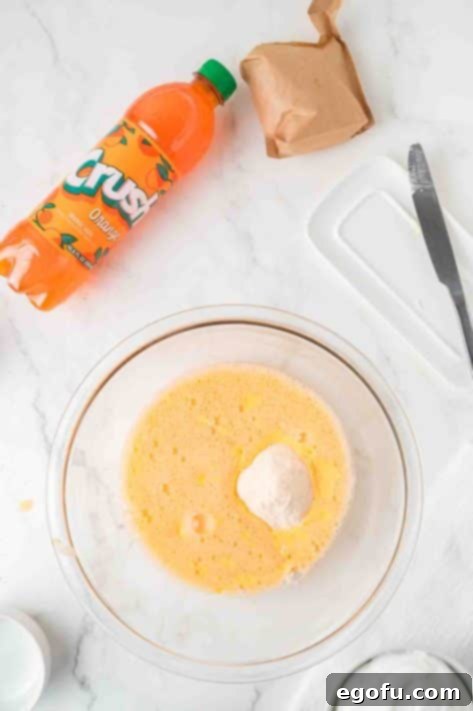 Zesty Orange Cream Pie 13 Orange soda and pudding mix being mixed together.