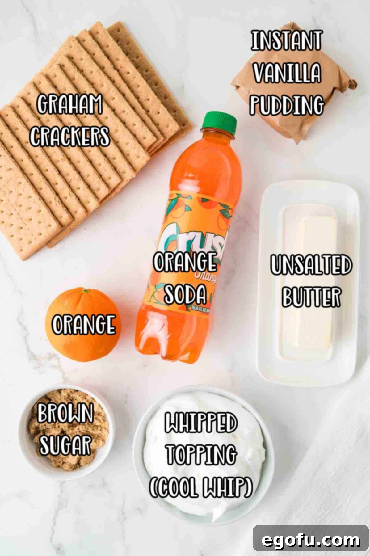 Zesty Orange Cream Pie 4 A colorful array of ingredients for Orange Creamsicle Pie, including graham crackers, orange soda, unsalted butter, instant vanilla pudding mix, fresh orange, brown sugar, and whipped topping.