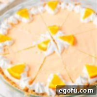 Zesty Orange Cream Pie 10 Closely looking down on an Orange Creamsicle Pie with garnishes, ready to be served.