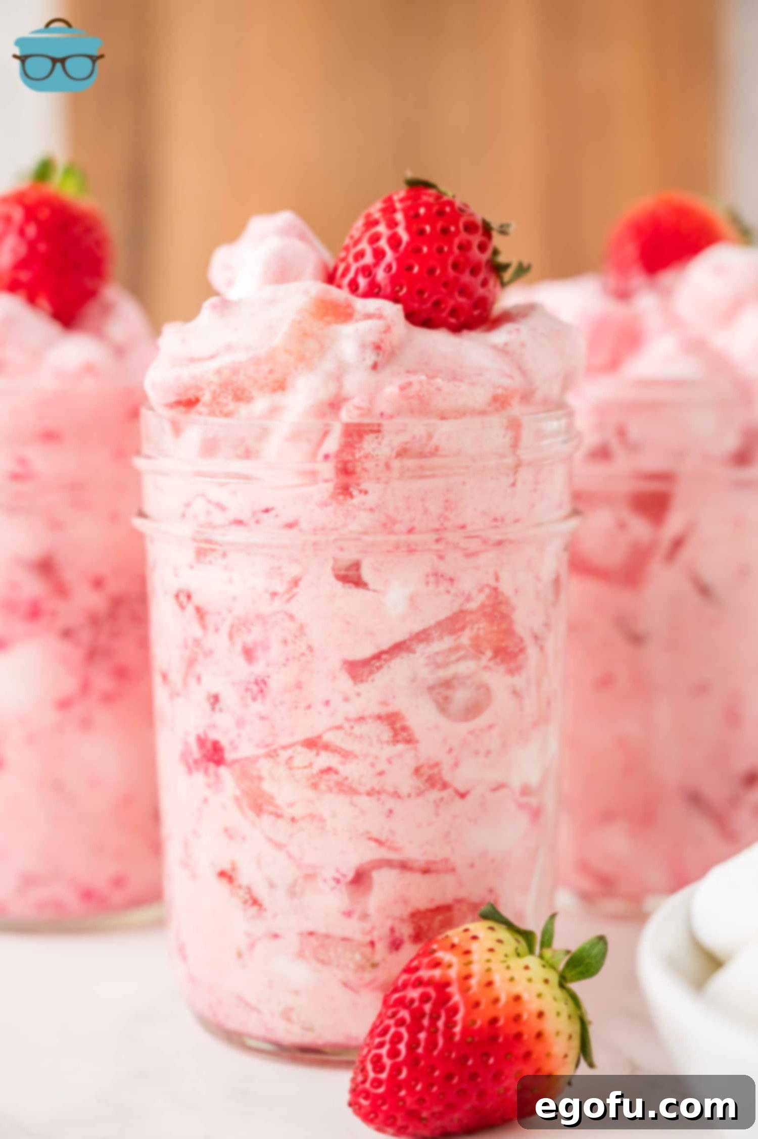 A few glasses of Strawberry Fluff with fresh strawberries on top.