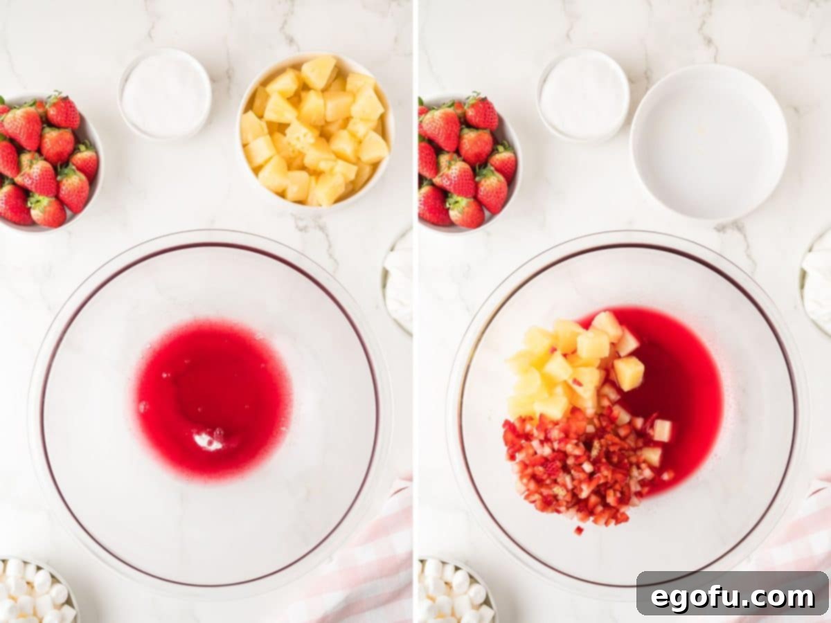 A bowl of strawberry jello, water, and fruit.
