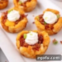 Four Loaded Tater Tot Cups on a plate, ready to be eaten.