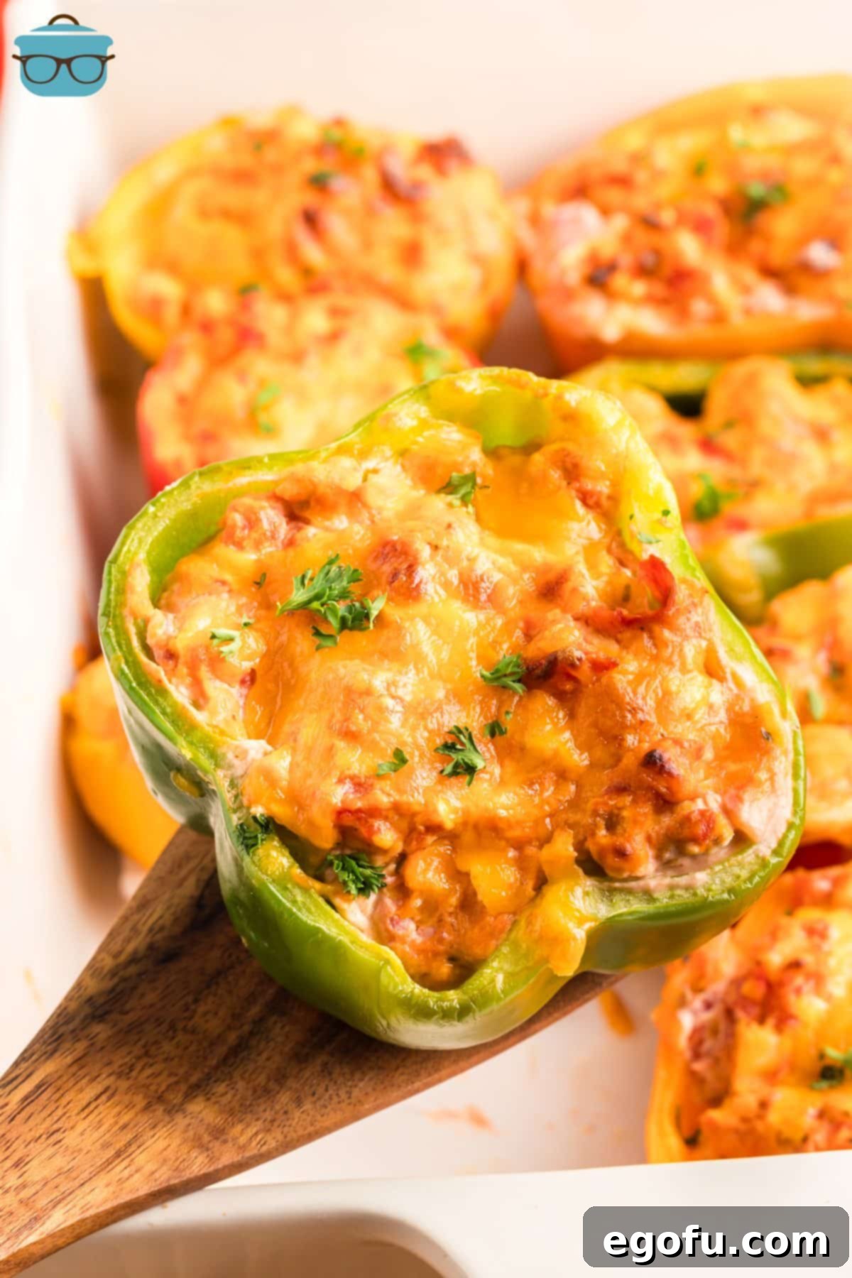Savory Chicken Stuffed Bell Peppers 2 A wooden spoon holding a Chicken Stuffed Pepper.