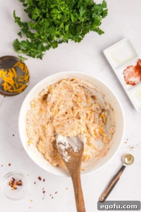 Savory Chicken Stuffed Bell Peppers 12 A bowl with shredded cheddar cheese, cream cheese, onion, paprika, Italian seasoning, garlic powder, onion powder, black pepper, salt, and red pepper flakes.