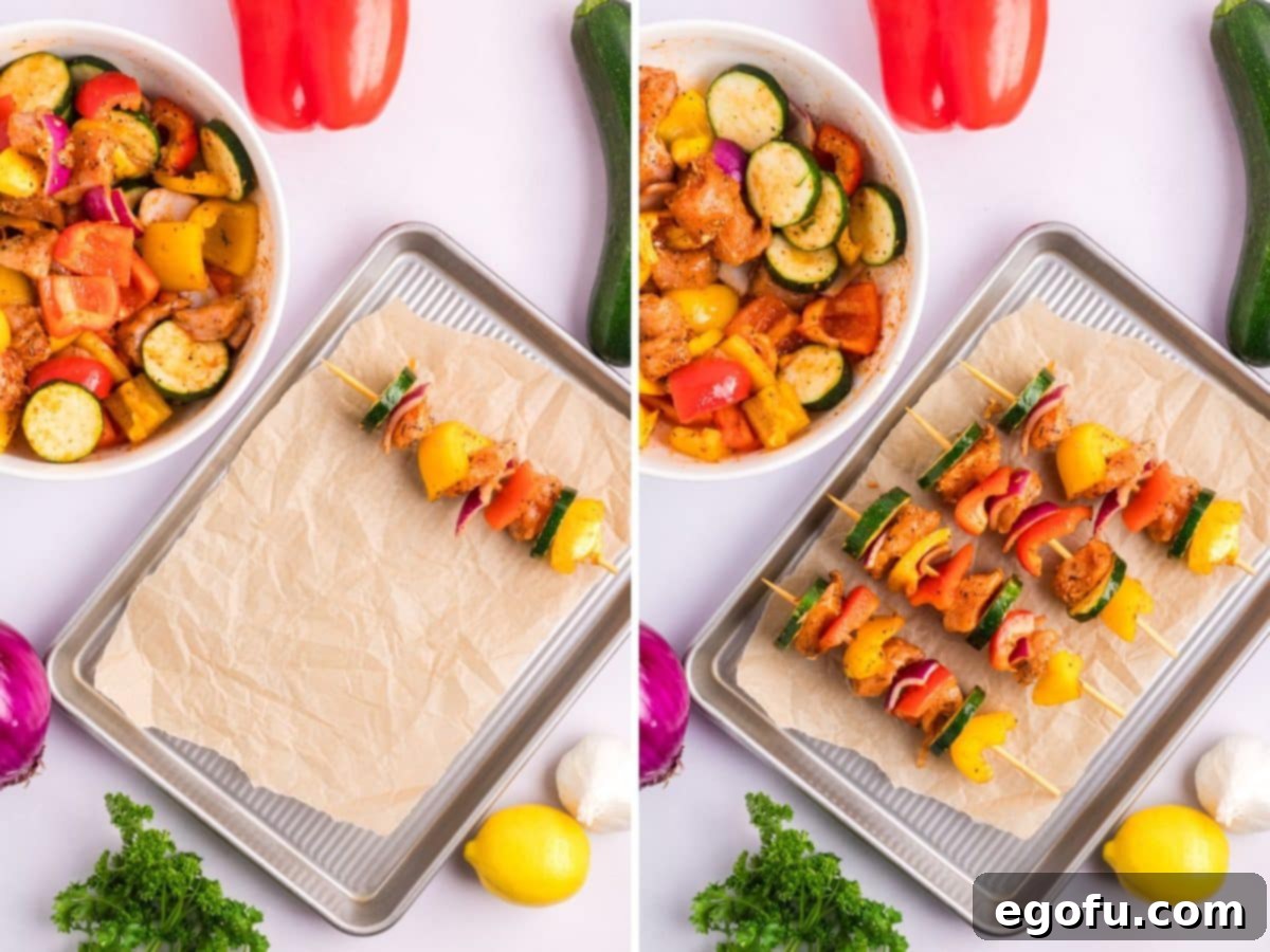 Chicken and vegetables being carefully alternated onto wooden skewers, which are then laid neatly onto a parchment-lined baking sheet, ready for the oven.