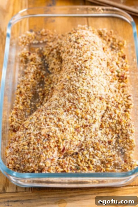 Coated pork tenderloin in a dish.