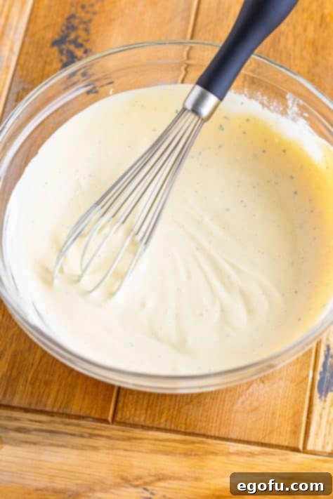 Sauce being mixed with a whisk in a bowl.