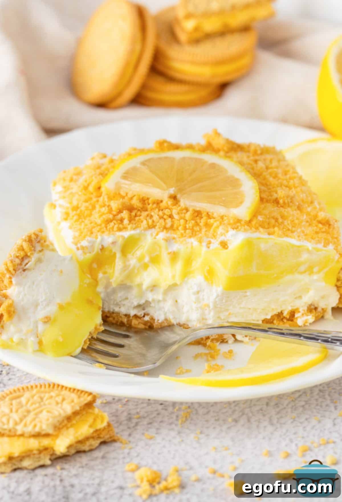 A fork holding a bite of Lemon Delight in front of a sliced portion on a plate, ready to be enjoyed.