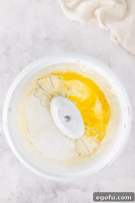 Lemon juice, zest, and cream cheese being mixed together.