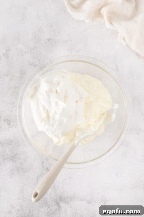 Cool Whip being folded in the mixture.