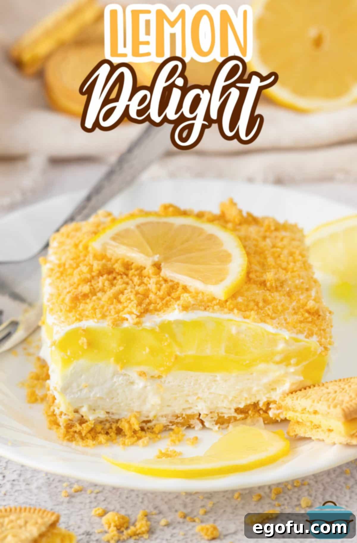 A large slice of lemon layered dessert on a white plate with lemon slices on it, highlighting its beautiful layers.