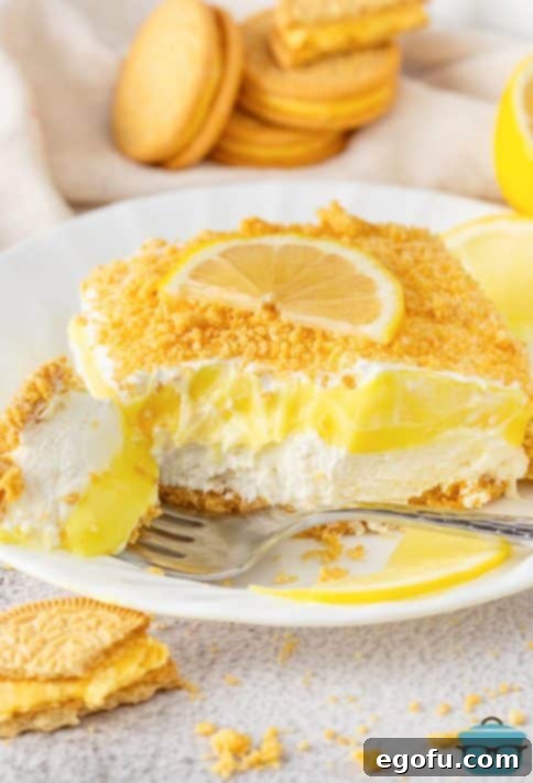 A fork holding a bite of Lemon Delight in front of a slice on a plate.