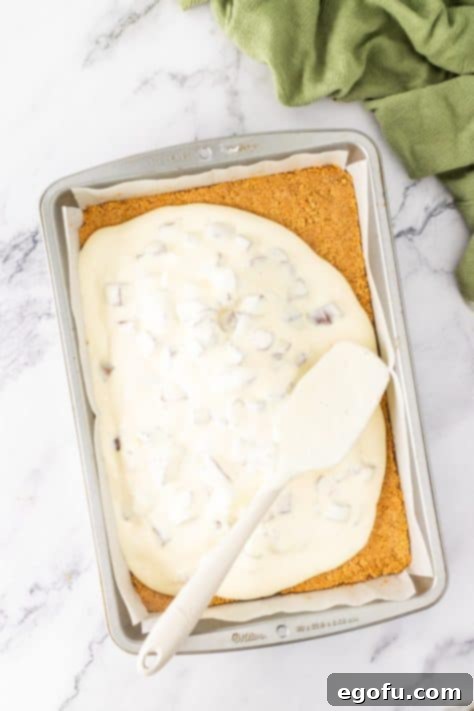 Cream cheese mixture over the graham cracker crumb crust in a baking dish.