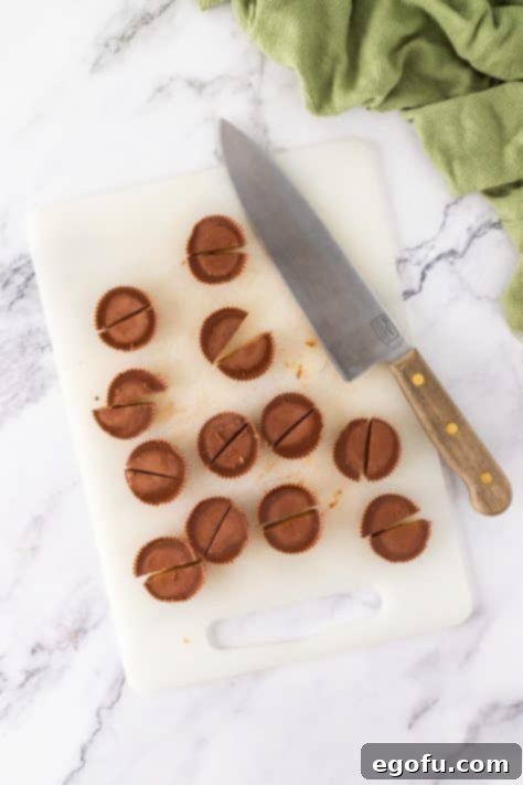 Reese's cups being cut on a cutting board.