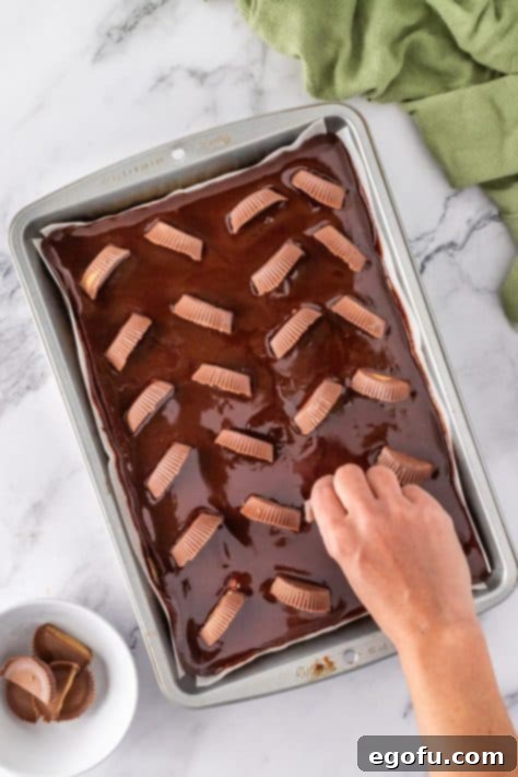Reese's peanut butter cups being added to dessert topping.