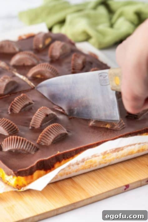 Reese's Cheesecake Bars being cut with a large knife.